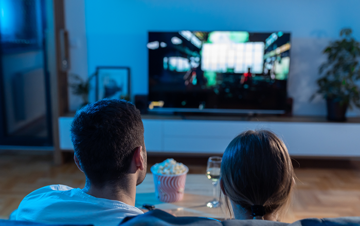 Man and woman watch movie on a couch